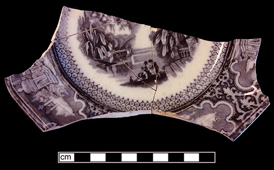 Printed underglaze refined white earthenware panelled cup with romantic motif pattern and continuous repeating linear border motif from 18BC27, Feature 30.  